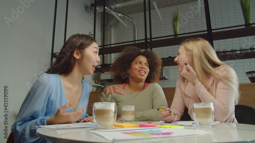 Wallpaper Mural Cheerful attractive diverse multiracial women in stylish outfit sitting at table, celebrating successful deal and giving high five gesture, expressing excitement and joy while relaxing at cafeteria. Torontodigital.ca