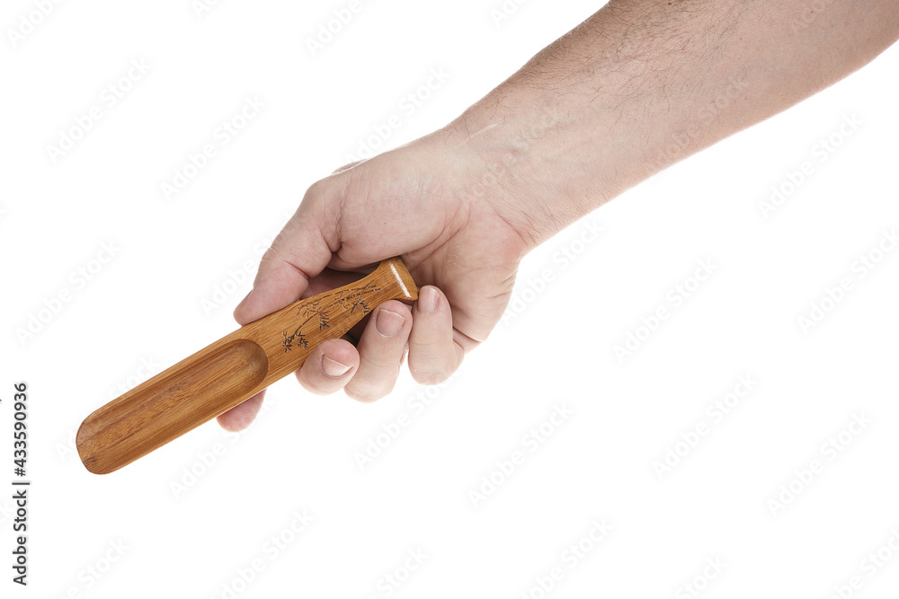 Hand holds a small wooden scoop for cereals on a white background Hand holds a small wooden scoop for cereals on a white background