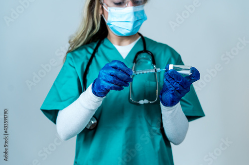 Female doctor or nurse holding COVID-19 Vaccine. Coronavirus medical treatment.