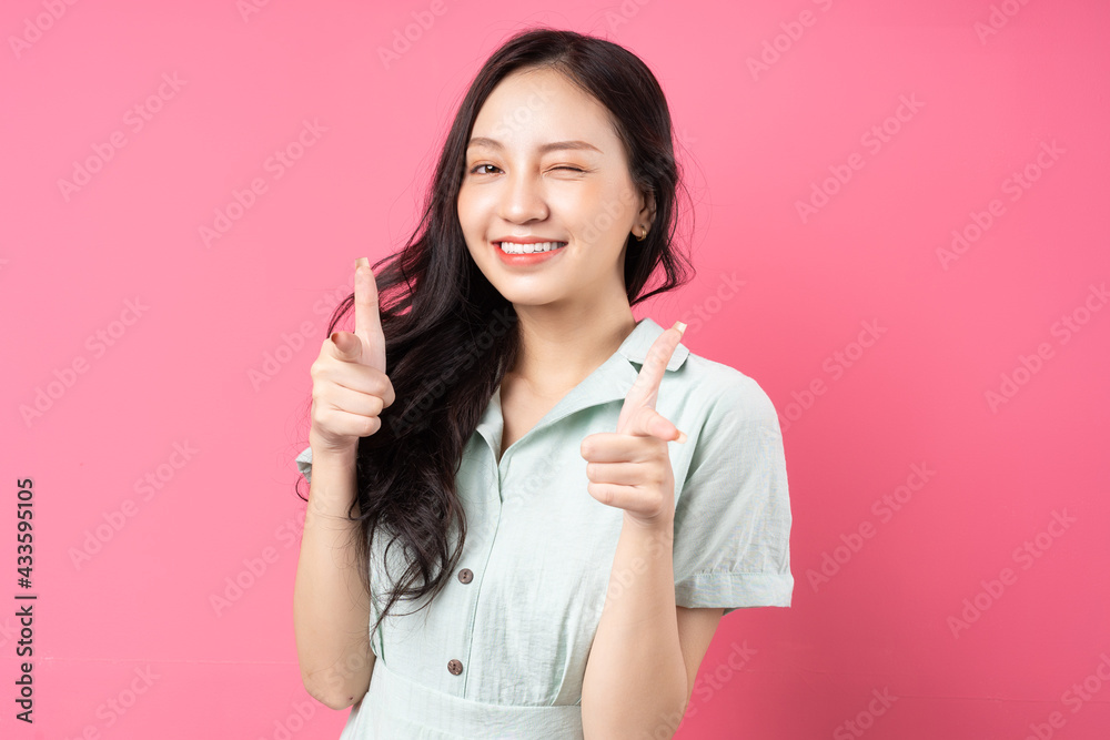 Young Asian woman pointing out with excited expression Young Asian woman pointing out with excited expression