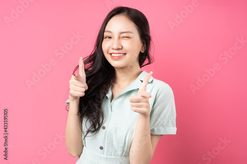 Young Asian woman pointing out with excited expression