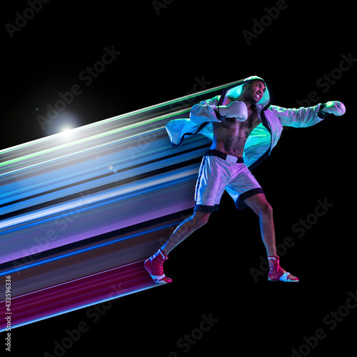 Abstract desing, concept of sport, action, motion in sport. Young african man boxing in neon light on black background