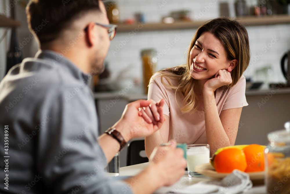 Beautiful young girl enjoying in breakfast with her boyfriend. Loving couple drinking coffee in the kitchen. Beautiful young girl enjoying in breakfast with her boyfriend. Loving couple drinking coffee in the kitchen.