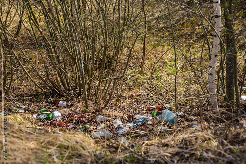 (environmental concept) Household garbage in the autumn forest, pollution of the environment and nature. Garbage - plastic waste, garbage in nature in the forest.