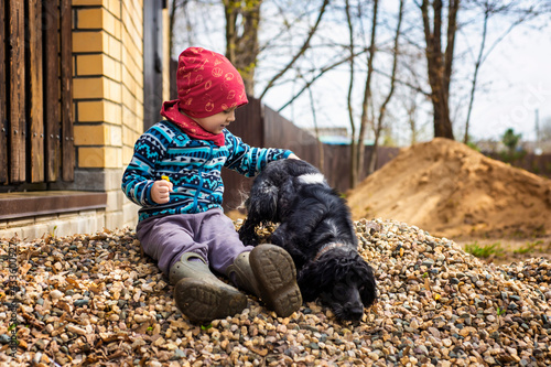 friendship of man and animal, boy and dog sitting on rocks, selective focus