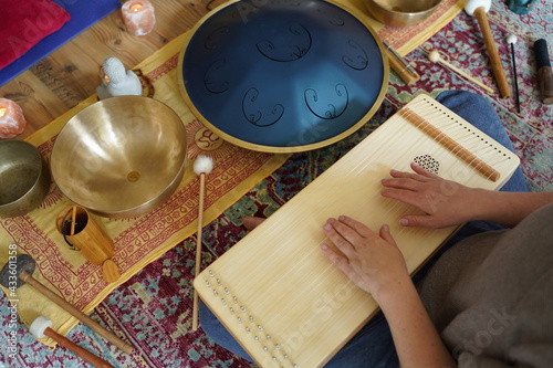 Caucasian woman holding a monochord, sound healing instrument in a therapy session, hands close up. photo