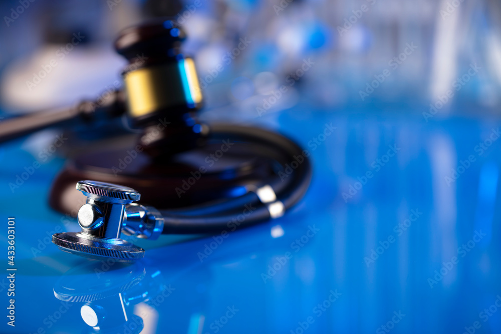 Medical law concept. Gavel and stethoscope on the glass table. Blue light. Medical law concept. Gavel and stethoscope on the glass table. Blue light.