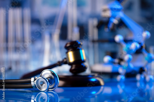 Medical law concept. Gavel and stethoscope on the glass table. Blue light.