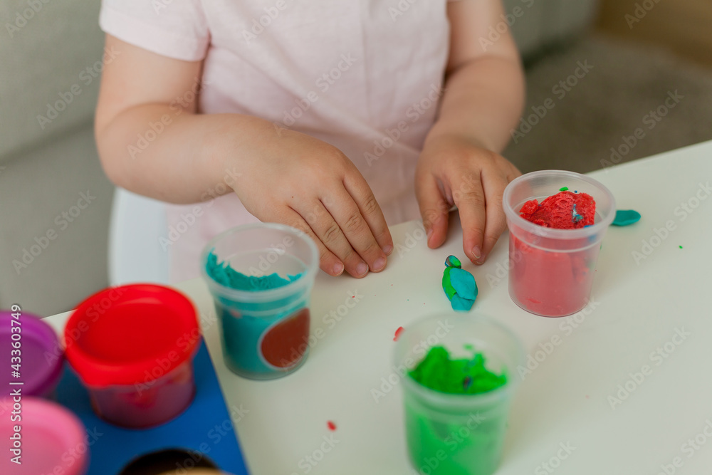 Little cute girl sculpts from colored plasticine. Development of children. Home. Little cute girl sculpts from colored plasticine. Development of children. Home.