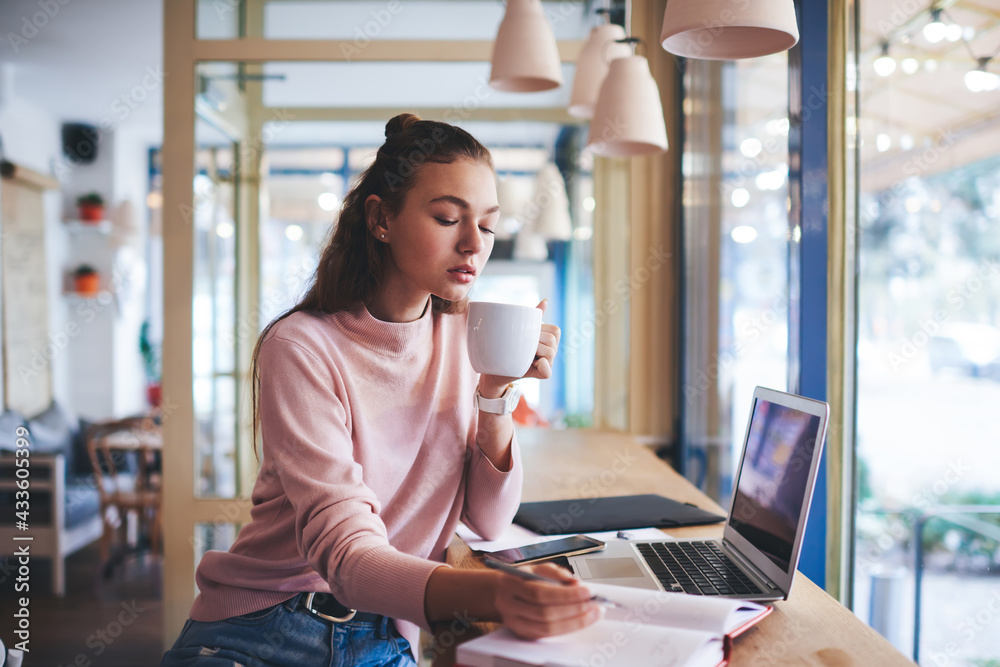 Calm freelancer writing notebook in cafeteria Calm freelancer writing notebook in cafeteria