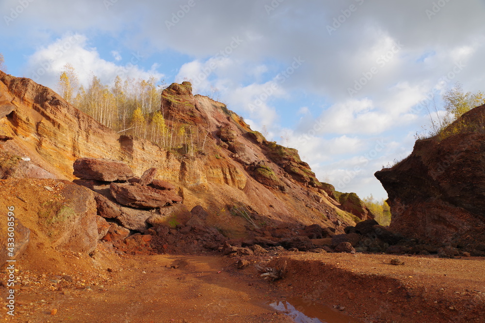 Fototapeta premium Red hills with birches against a blue sky.