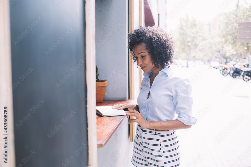 Young woman reading diary standing at street bar counter Young woman reading diary standing at street bar counter