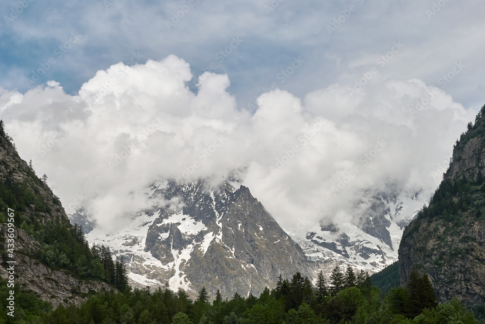 Panorama of a valley with peaks immersed in the clouds in Courmayeur, Val d'Aosta, Italy Panorama of a valley with peaks immersed in the clouds in Courmayeur, Val d'Aosta, Italy