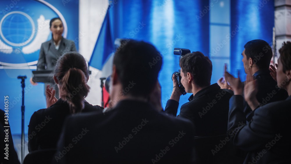 Fototapeta premium Pool of Photographers and Journalists Working at a Organization Press Conference with Female Representative Delivering a Speech at Press Conference in Government Building. Diplomat at a Summit.