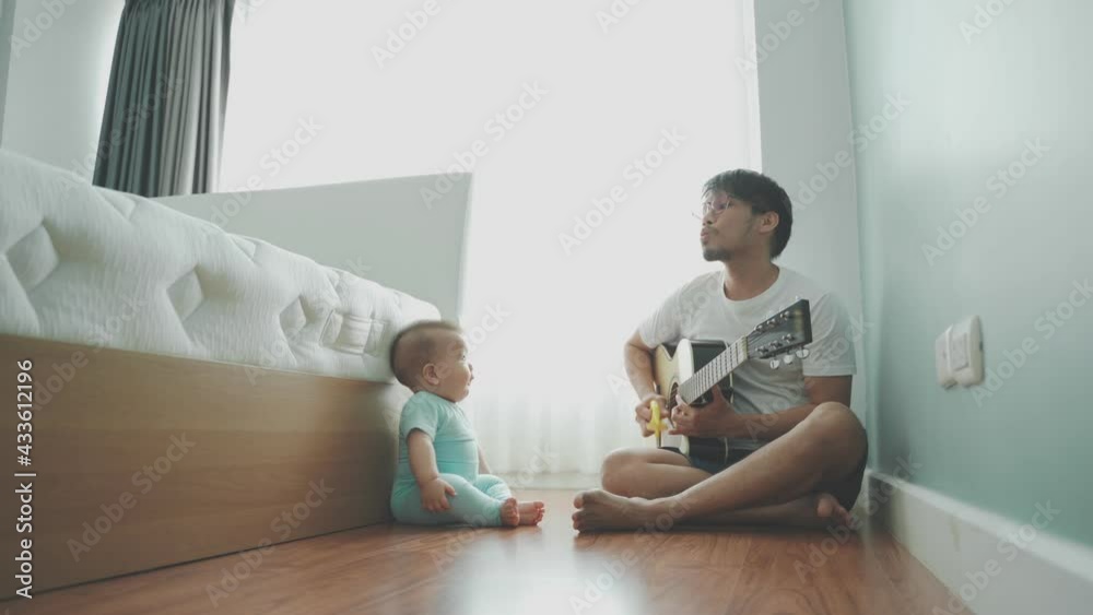 Leisure Happy Asian Father and little baby playing acoustic guitar at home. Leisure Happy Asian Father and little baby playing acoustic guitar at home.