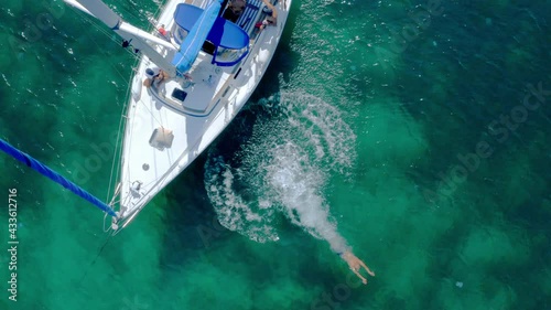 Aerial view of a tourist man jumping in the water from a yacht, 4k slow motion