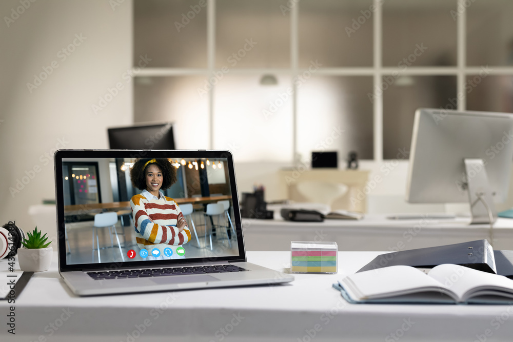 Laptop computer with a video call from businesswoman lying on desk Laptop computer with a video call from businesswoman lying on desk