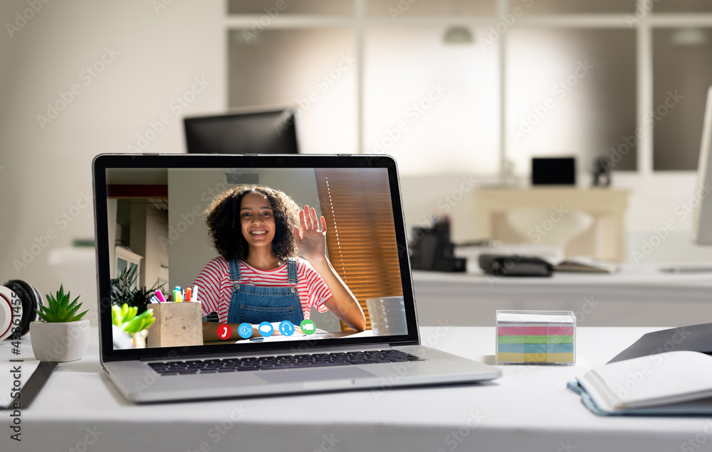 Laptop computer with a video call from businesswoman lying on desk Laptop computer with a video call from businesswoman lying on desk