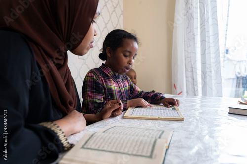 Mother and children reading quran together