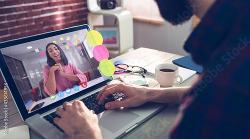 Caucasian businessman sitting at desk using laptop having video call with female colleague photo