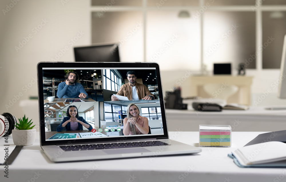 Caucasian men and women having business video call on screen of laptop on desk Caucasian men and women having business video call on screen of laptop on desk