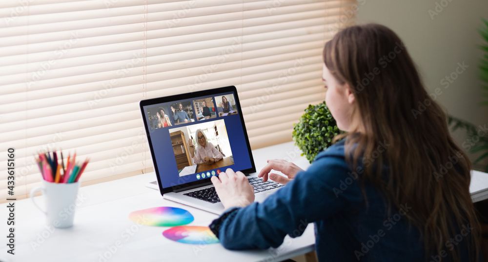 Caucasian girl sitting at desk, using laptop, having online lesson Caucasian girl sitting at desk, using laptop, having online lesson