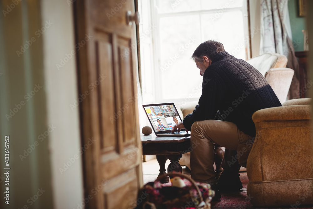 Senior man sitting on sofa using laptop having video call Senior man sitting on sofa using laptop having video call