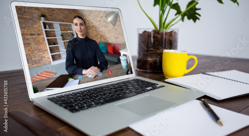 Caucasian woman havin gvideo call on screen of laptop on desk photo