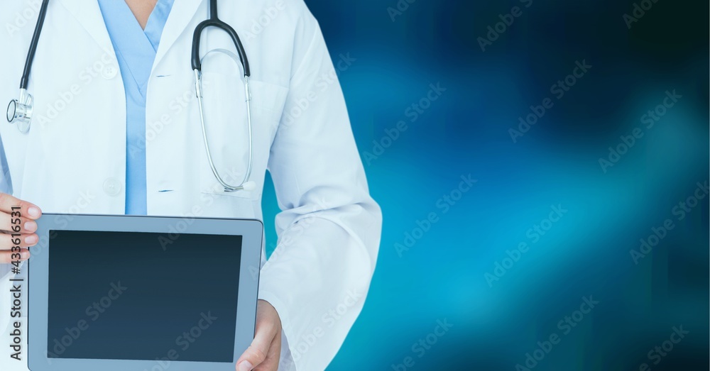 Composition of midsection of female doctor in lab coat holding tablet over blue background Composition of midsection of female doctor in lab coat holding tablet over blue background