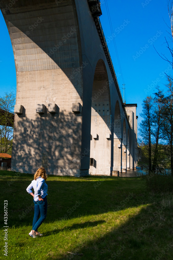 Stockholm, Sweden A woman stands in the shadow of the Arsta bridge on Arsta island.