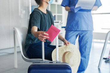 Close up woman holding passport and luggage during medical test