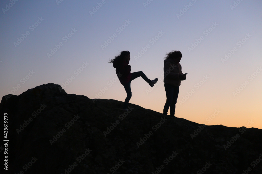 silhouettes of people in the mountain with sunrise sky background