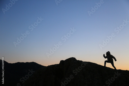 silhouettes of people in the mountain with sunrise sky background © fotoXS