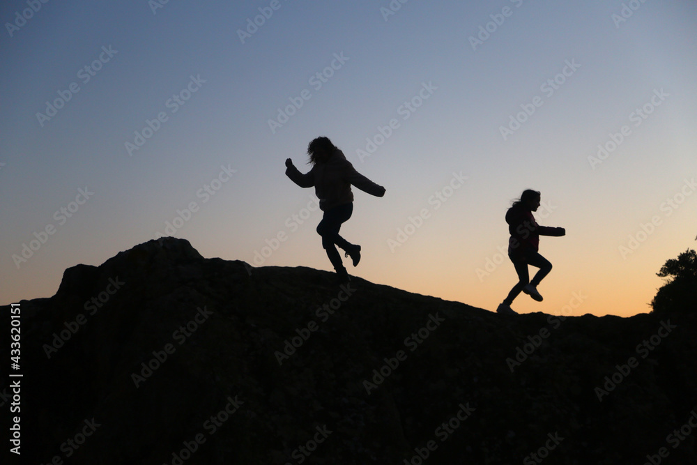 silhouettes of people in the mountain with sunrise sky background