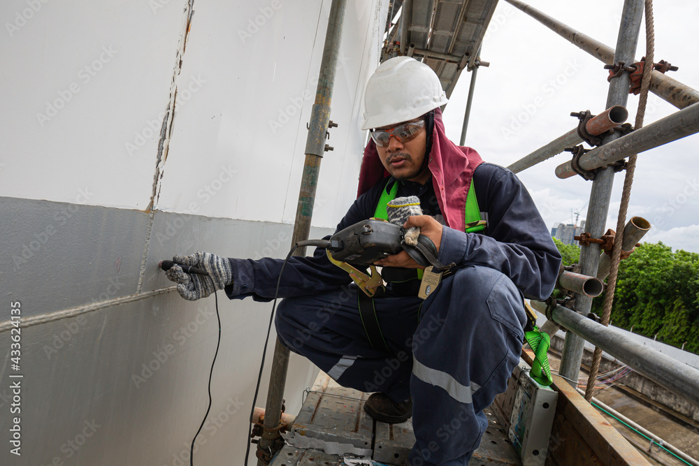 Male worker scaffolding are for inspection ultrasonic thickness shell plate of storage tank Male worker scaffolding are for inspection ultrasonic thickness shell plate of storage tank