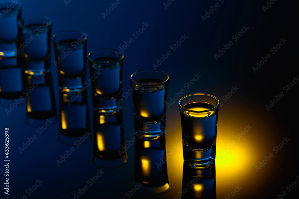 Strong alcoholic drink in color bright lights. - obrazy, fototapety, plakaty 