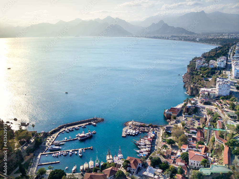 Aerial photograph of Antalya bay in Antalya city from high point of drone fly on sunny day in in Turkey. Amazing aerial cityscape view from birds fly altitude on beautiful town and sea full of yahts