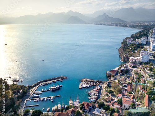 Fototapeta Naklejka Na Ścianę i Meble -  Aerial photograph of Antalya bay in Antalya city from high point of drone fly on sunny day in in Turkey. Amazing aerial cityscape view from birds fly altitude on beautiful town and sea full of yahts