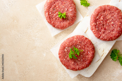 Meat for burgers. Raw cotlests to cook burgers. Cooking homemade meat sandwitches. Top view, copy space. photo