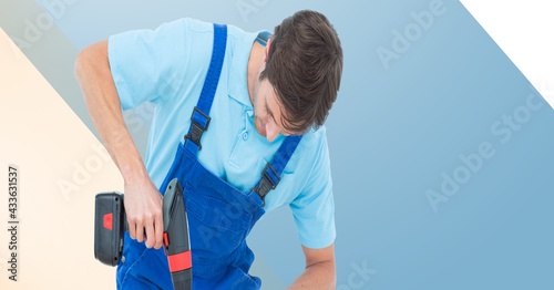 Midsection of handy man holding drill on blue, beige and white stripes