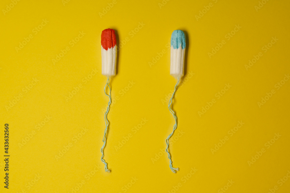 Tampons soaked in blue and red fluid as concept of uncomfortable female truth shown in advertisements for mentruation products