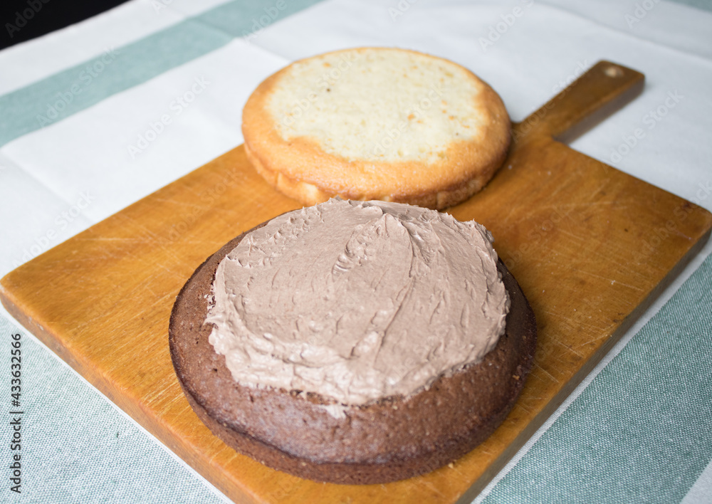 The process of making a cake at home. Household chores. A fresh homemade cake is on a wooden board. two sponge cakes, a cream layer, chocolate ganache. Series of photos with a step-by-step recipe The process of making a cake at home. Household chores. A fresh homemade cake is on a wooden board. two sponge cakes, a cream layer, chocolate ganache. Series of photos with a step-by-step recipe