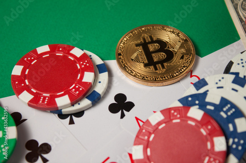 Classic playing cards, chips, red dice, bitcoin and dollars on green background.