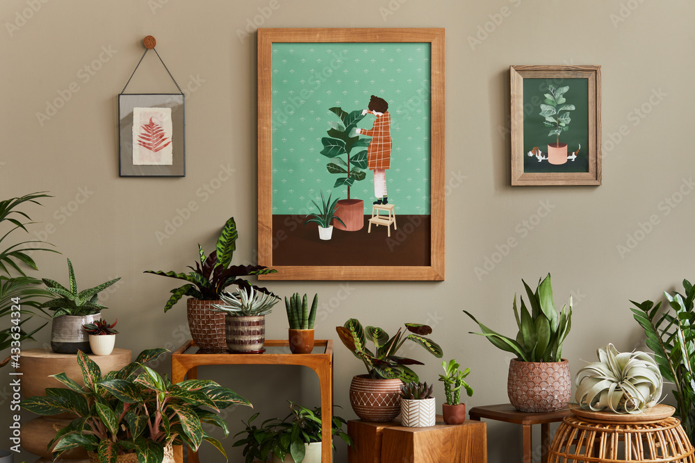 Stylish botany composition of home garden interior with wooden mock up poster frame, filled a lot of beautiful house plants, cacti, succulents in different design pots and floral accessories. Template Stylish botany composition of home garden interior with wooden mock up poster frame, filled a lot of beautiful house plants, cacti, succulents in different design pots and floral accessories. Template