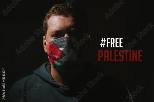 man with face mask and palestinian flag with text free palestine