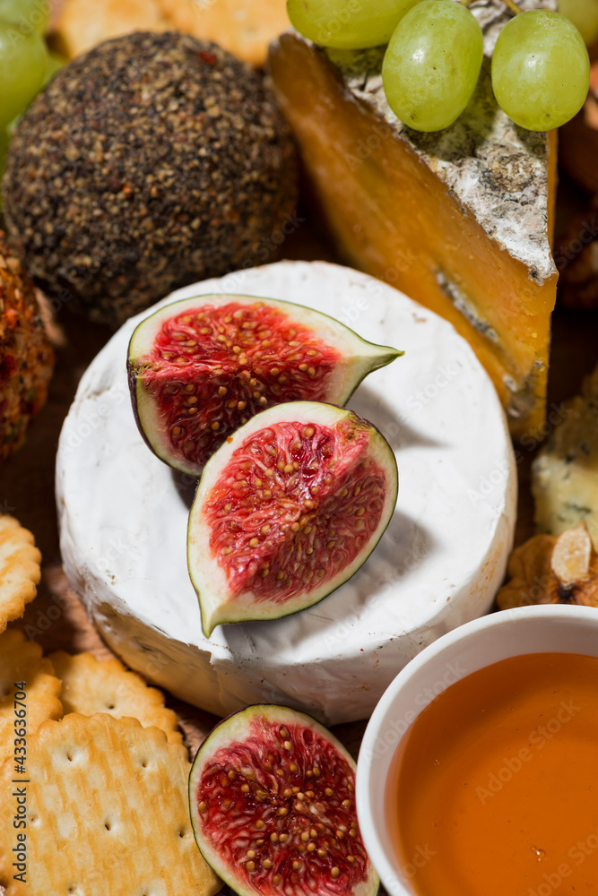 delicious snacks, cheese, crackers and fresh fruits, vertical closeup delicious snacks, cheese, crackers and fresh fruits, vertical closeup