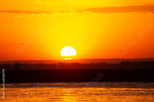 Fototapeta Naklejka Na Ścianę i Meble -  orange sunset by the water, the sun in the sky 