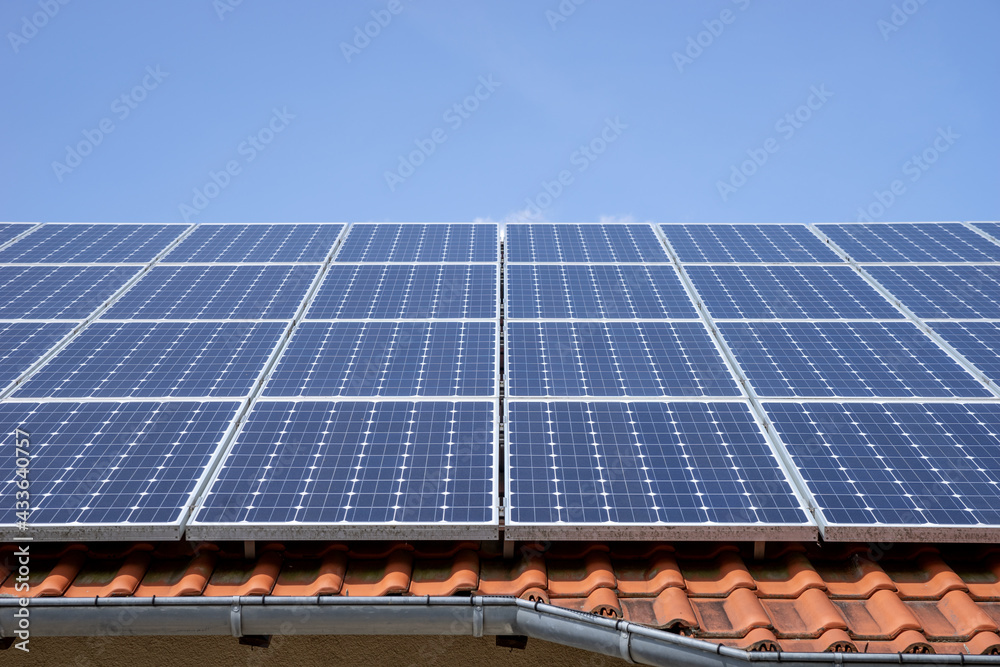 Solar photovoltaic panels on the roof with blue sky in the background Solar photovoltaic panels on the roof with blue sky in the background