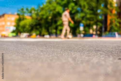 Summer in the city, pedestrian crossing the road. Close up view from the asphalt level