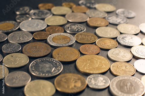 A set of coins of different countries located on a black background.